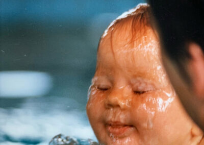 Säugling wird mit Wasser übergossen